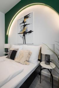 a bedroom with a white bed and a green wall at R6 - Boutique Apartments, Best Location By BQA in Budapest