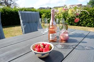 - une table avec un bol de fraises et une bouteille de vin dans l'établissement Landloft Nedderby, à Husby