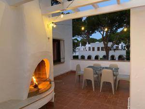 un patio con chimenea, mesa y sillas en Casa Pinyera - Plus Costa Brava, en Pals