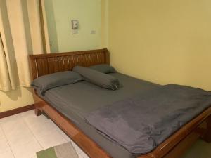 a bedroom with a bed with a wooden frame at รีสอร์ท สุพรรณ in Suphan Buri