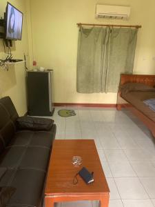 - un salon avec un canapé et une table basse dans l'établissement รีสอร์ท สุพรรณ, à Suphanburi