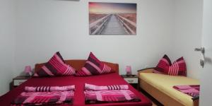a bedroom with two beds with pink and purple pillows at Apartmani kod Rade in Pakoštane