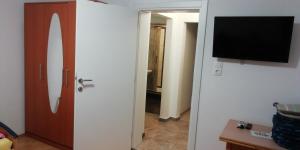 a room with a door and a tv on a wall at Apartmani kod Rade in Pakoštane
