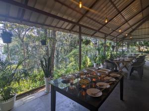une salle à manger avec des tables, des chaises et des arbres dans l'établissement Avadale Munnar (Stag Groups Not Allowed), à Chinnakanal