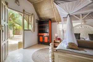 ein Schlafzimmer mit einem Bett mit einem weißen Baldachin in der Unterkunft Cinnamon Hotel in Jambiani