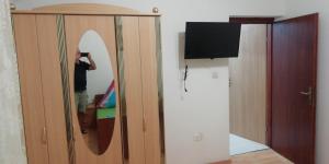 a man taking a picture of a surfboard in a mirror at Apartmani kod Rade in Pakoštane