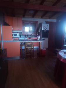 cocina con armarios rojos y nevera blanca en casa vacacional, en Ledaña