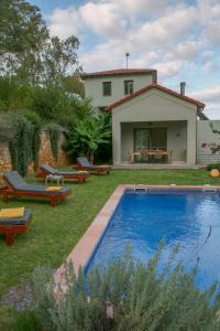 a backyard with a swimming pool and a house at Physis Villas Chania in Ayiá