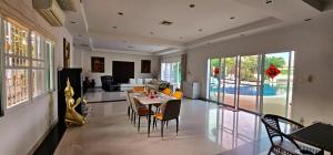 a dining room and living room with a table and chairs at Rawai pool Villa in Phuket Town