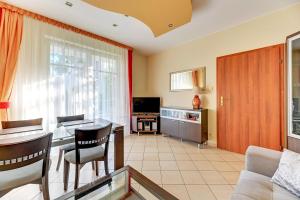 ソポトにあるGrand Apartments - Patio Mare Apartmentsのリビングルーム(テーブル、椅子、テレビ付)