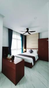 a bedroom with a bed with a ceiling fan at Xan hotel Phu Quoc in Phu Quoc