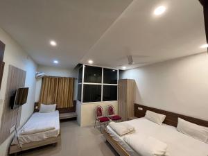 1 dormitorio con 2 camas y ventana en Hotel Pratap Heights en Ranchi