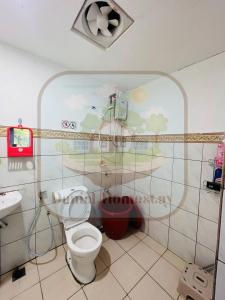 uma casa de banho com WC e uma pintura na parede em Danial Homestay Semporna em Semporna