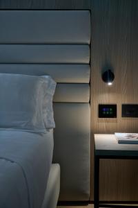 a bedroom with a bed and a nightstand with a clock at RMH Modena Raffaello in Modena