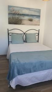 a bedroom with a bed with a blue blanket at Casa Nina in Linares