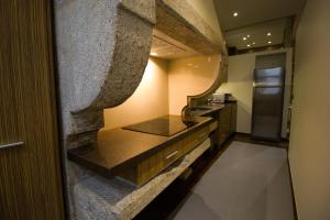 a kitchen with a counter and a stone wall at Apartamentos Turísticos Pacios in Santiago de Compostela