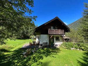 a small house with a balcony on a green field at Kleine Ahornau in Schladming