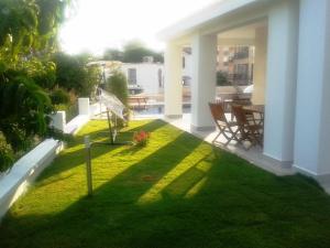 a patio with a lawn with a table and chairs at Lighthouse Lydia Villas in Fethiye