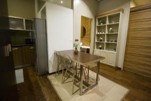 a kitchen with a table and chairs and a refrigerator at Apartamentos Turísticos Pacios in Santiago de Compostela