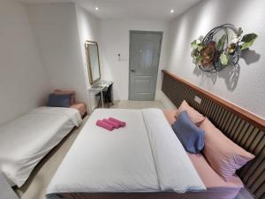 a bedroom with two beds with pink and blue pillows at One Point Hotel in Kuching