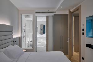 a bedroom with a white bed and a mirror at RMH Modena Raffaello in Modena