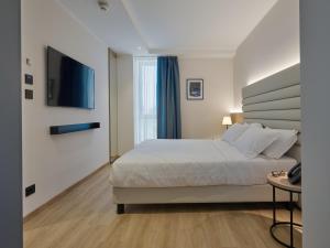 a bedroom with a bed and a flat screen tv at RMH Modena Raffaello in Modena