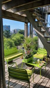 un patio con sedie verdi e tavoli all'interno di un edificio di Location chambre privée avec salle de bain et WC privatifs dans appartement moderne a Nantes