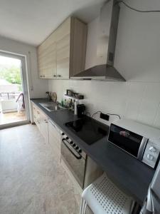 una cocina con encimera negra y fregadero en MG06 Schickes Apartment in Zentrumsnähe en Mönchengladbach