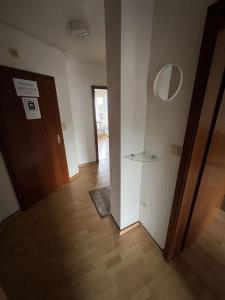 pusty pokój z drzwiami i drewnianą podłogą w obiekcie MG06 Schickes Apartment in Zentrumsnähe w mieście Mönchengladbach