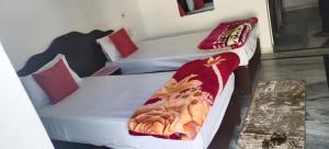 2 łóżka pojedyncze w sypialni z kocem w obiekcie Karma Hostel w mieście Khajuraho