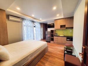 1 dormitorio con 1 cama grande y cocina en Mother's Home, en Ho Chi Minh