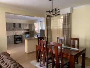 eine Küche und ein Esszimmer mit einem Tisch und Stühlen in der Unterkunft Happy home from home in Kitengela 