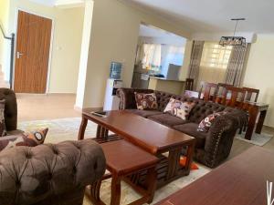 ein Wohnzimmer mit einem Sofa und einem Tisch in der Unterkunft Happy home from home in Kitengela 