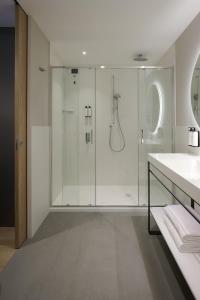 a bathroom with a glass shower and a sink at RMH Modena Raffaello in Modena