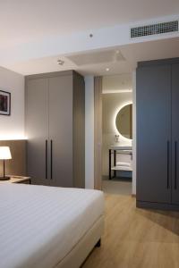 a bedroom with a white bed and a bathroom at RMH Modena Raffaello in Modena