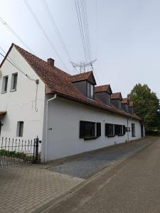 a white building with a red roof on a street at Eros residentie in Geel