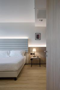 a bedroom with a bed and a table with a lamp at RMH Modena Raffaello in Modena