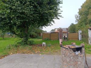 a trash can in a yard with a tree at Eros residentie in Geel