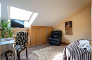 a attic room with a bed and a chair and a desk at Atico Eufrasio in Lerma