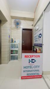 a hospital room with a reception sign in front of a building at Hotel City Panthapath in Dhaka