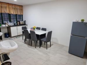 een keuken met een tafel en stoelen en een koelkast bij One Point Hotel in Kuching