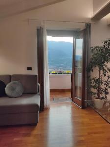 a living room with a couch and a sliding glass door at Ai Cappuccini, Trento a 360 gradi in Trento