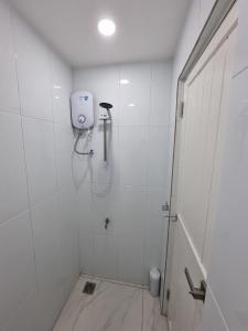 a white bathroom with a shower with a shower at One Point Hotel in Kuching