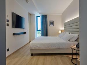 a hotel room with a bed and a television at RMH Modena Raffaello in Modena