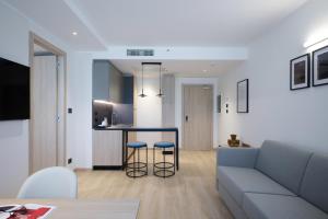 ein Wohnzimmer und eine Küche mit einem Sofa und einem Tisch in der Unterkunft RMH Modena Raffaello in Modena