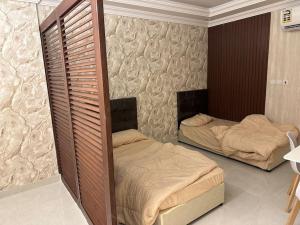 two beds in a room with twoperate beds in it at Ammash Services and Hotel Rooms in Jeddah