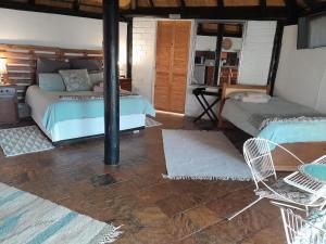 ein Schlafzimmer mit einem Bett und Stühlen in einem Zimmer in der Unterkunft The Lapa Apartment in Gobabis