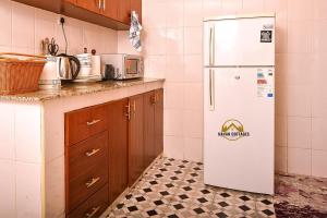 uma cozinha com um frigorífico branco e piso em azulejo em Havan Furnished Apartment-Milimani N9 em Nakuru