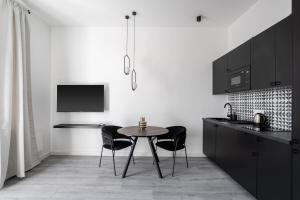a kitchen with a table and chairs in a room at R6 - Boutique Apartments, Best Location By BQA in Budapest