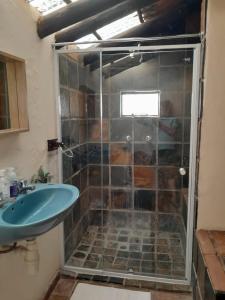 La salle de bains est pourvue d'une douche et d'un lavabo. dans l'établissement The Lapa Apartment, à Gobabis
